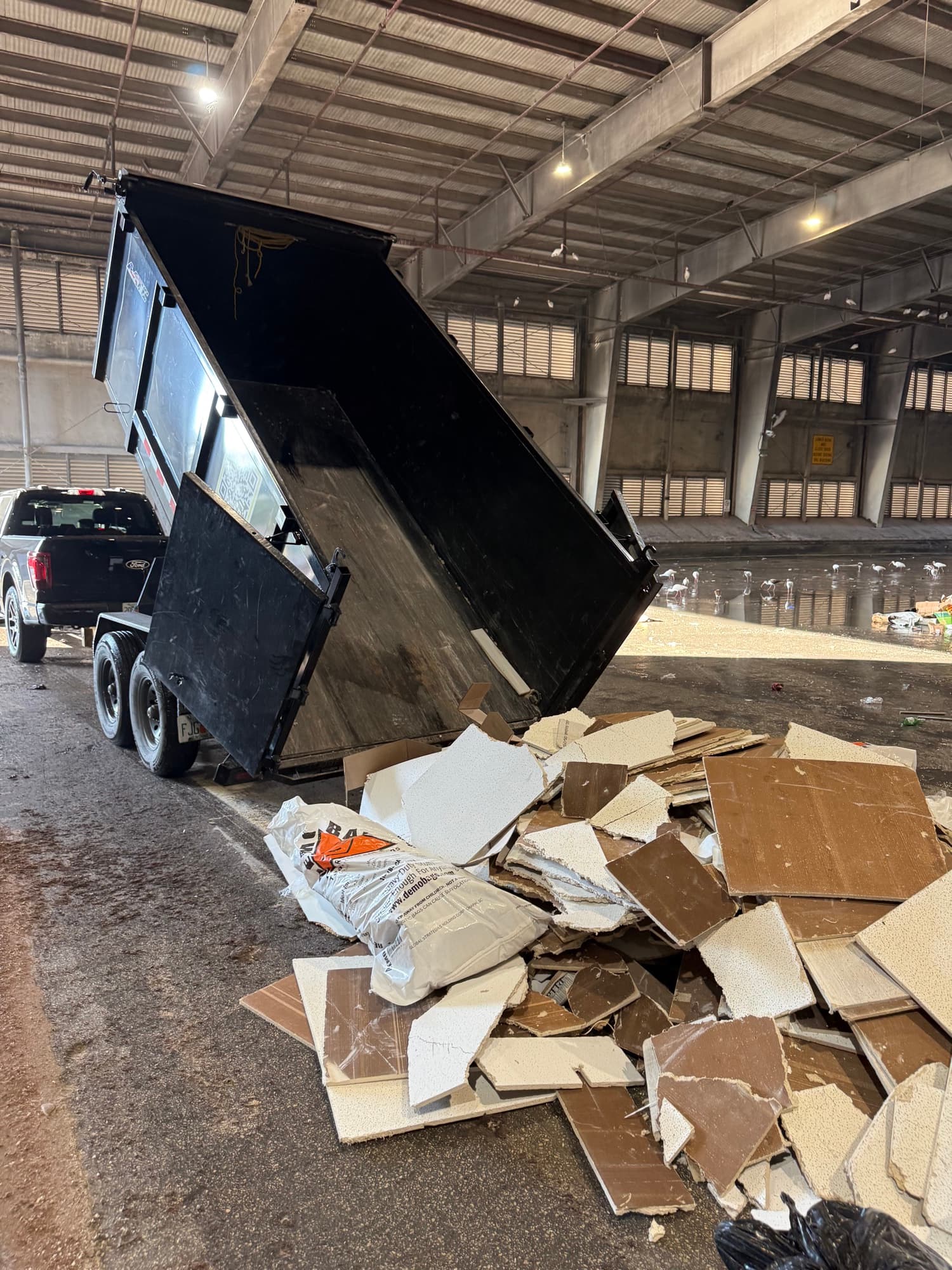 Safe USA Transport dump trailer tipping a load of drywall debris at a transfer station